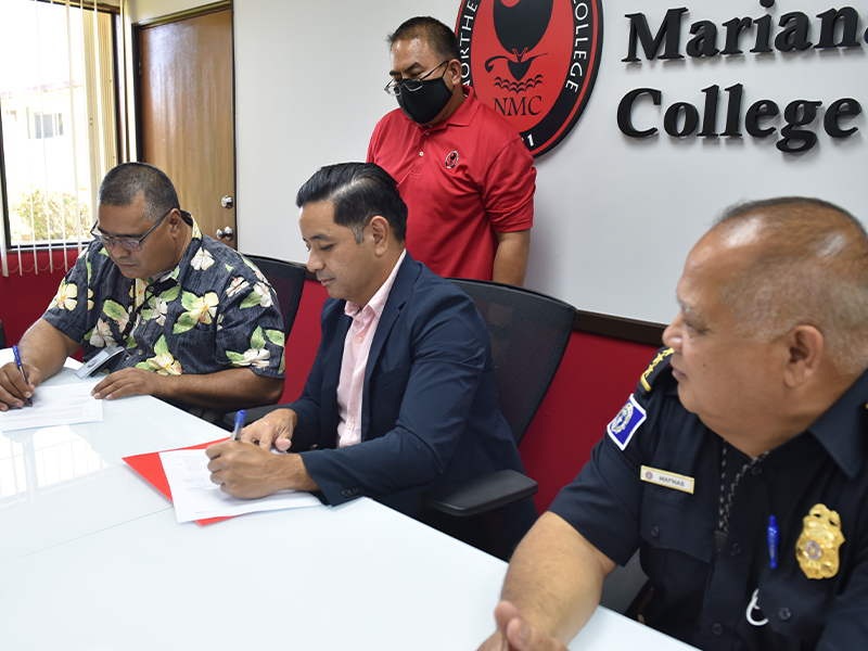 Finance Secretary David DLG Atalig, left, and Northern Marianas College Interim President Frankie Eliptico, center, sign a memorandum of agreement as Customs Director Jose Mafnas, right, and NMC Criminal Justice Program Coordinator Clement R. Bermudes look on in the NMC Board of Regents conference room on Friday.