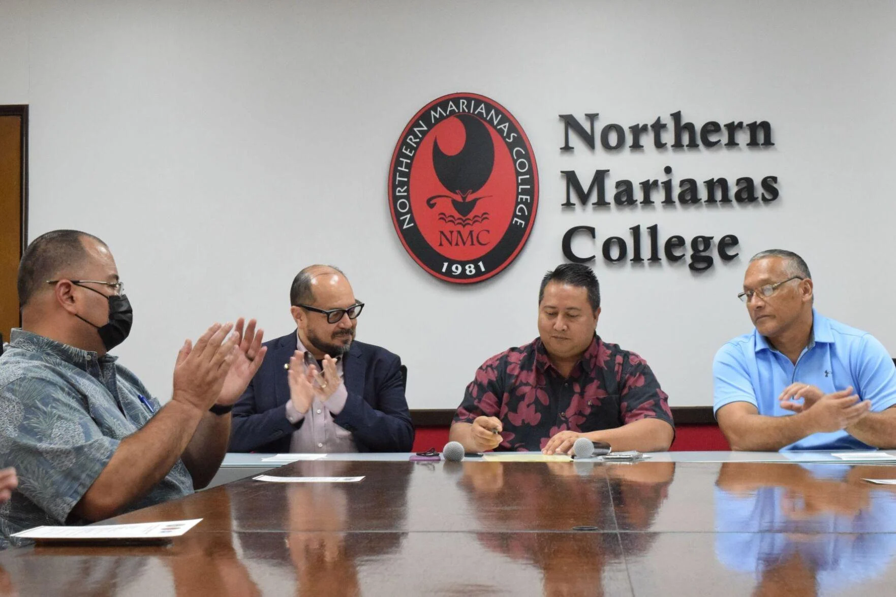 Northern Marianas College President Dr. Galvin Deleon Guerrero, second left, Speaker Edmund S. Villagomez, left, and NMC Board of Regent Chairman Charles Cepeda, right, applaud after Gov. Ralph DLG Torres signed the proclamation declaring April as Community College Month in the NMC board conference room on Monday. Photo by Emmanuel T. Erediano