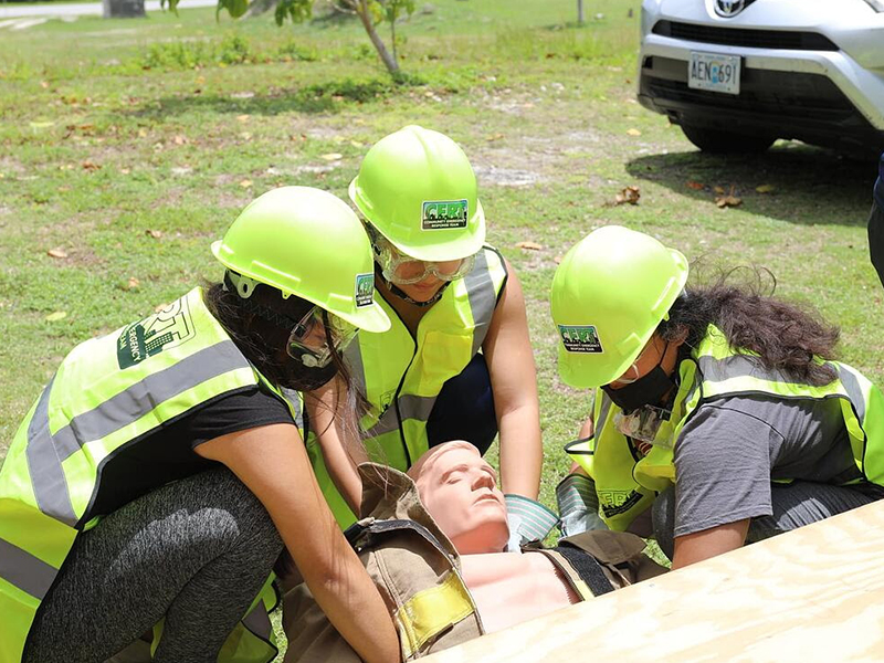 Northern Marianas College’s My Preparedness Initiative (MyPI) Rota members Shaniyah Cabrera, Hanna Ogo, and Freya Greathouse  conduct a “Cribbing” exercise where they remove the “victim” out from under a heavy wooden board.